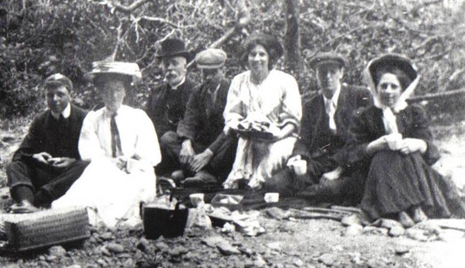 A vintage photo of a group of people posing for the camera
Description automatically generated
